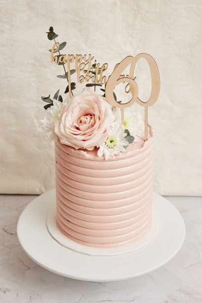 垂直高角度特写一个60岁的生日蛋糕在转盘与浅粉色糖霜图片下载