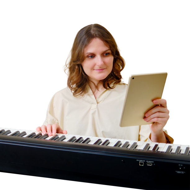 女音乐家与平板电脑弹奏电子钢琴在家里沙发在客厅，孤立的白色背景图片下载
