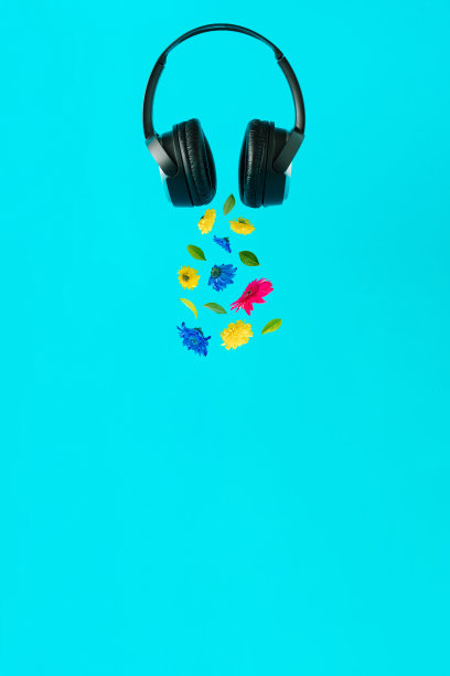 音乐耳机和五彩缤纷的花朵从耳垫中分离出来，在淡蓝色的空间复制图片下载