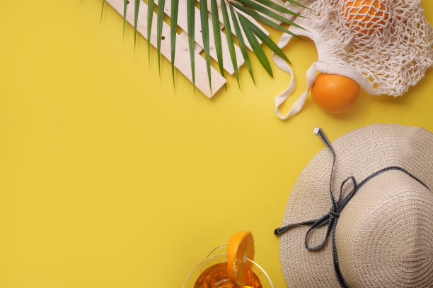 白色防晒霜，夏日帽子，棕榈枝，黄色背景上的橙子，夏日概念图片下载