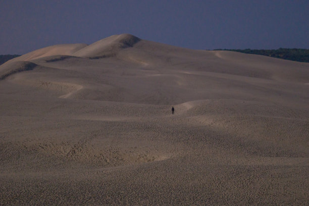 男人孤独的剪影走在巨大的沙丘杜彼拉特沙丘在夜间月光照亮，阿卡康，新阿基坦，法国图片下载