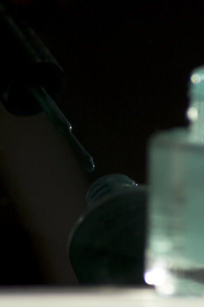 亮色指甲油。瓶子反射在黑色光滑的表面上图片下载