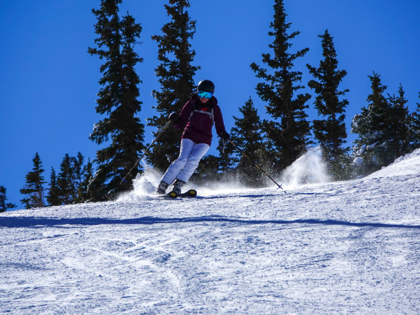 成熟的女子滑雪在阳光明媚的不拥挤的斜坡。科罗拉多州阿斯彭的雪场。图片下载
