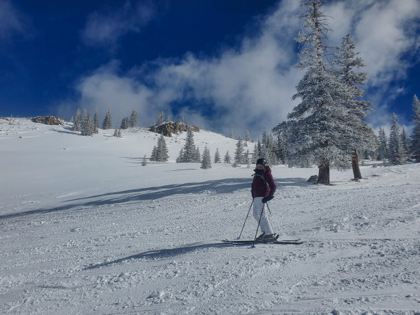 成熟的女子滑雪在阳光明媚的不拥挤的斜坡。科罗拉多州阿斯彭的雪场。图片下载