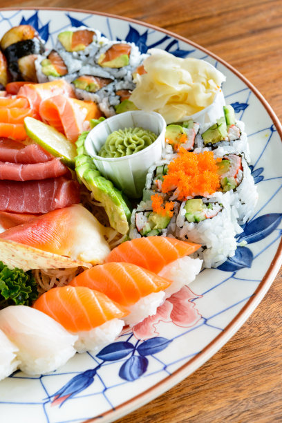 什锦寿司和生鱼片在大古董手绘日本盘核桃木桌子图片下载