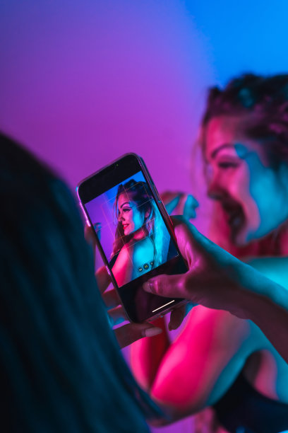 移动肖像的白人金发女孩在夜总会化妆安排在一个蓝色的背景图片下载