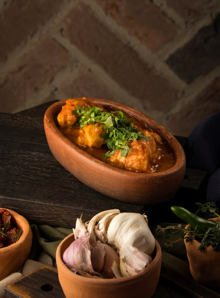 垂直照片上的一盘酸奶油酱牛肉和一碗大蒜在桌子上图片下载