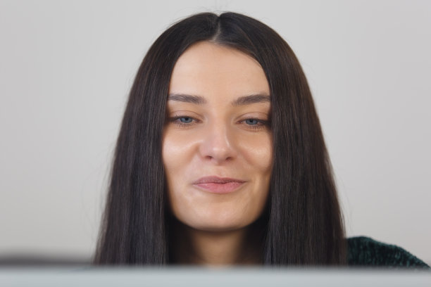 美丽的年轻女子在笔记本电脑上在线学习。特写照片的吸引力白色女性阅读文字从笔记本电脑屏幕图片下载