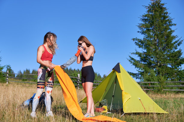 两位女游客穿着运动服，在山上徒步旅行。图片下载