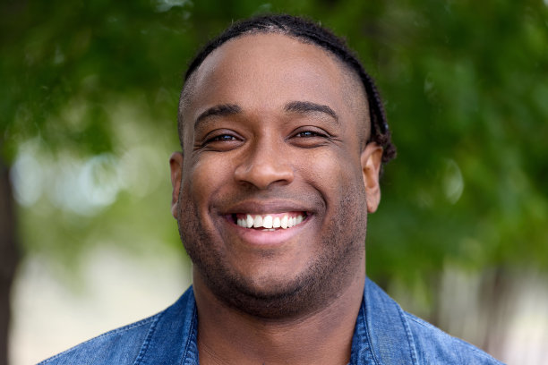 一名身穿牛仔衬衫的非洲青年在镜头前微笑图片下载