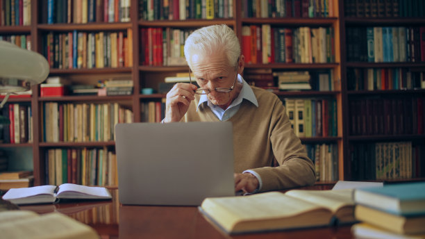 资深男性作家打开笔记本电脑，开始他小说书的新篇章图片下载