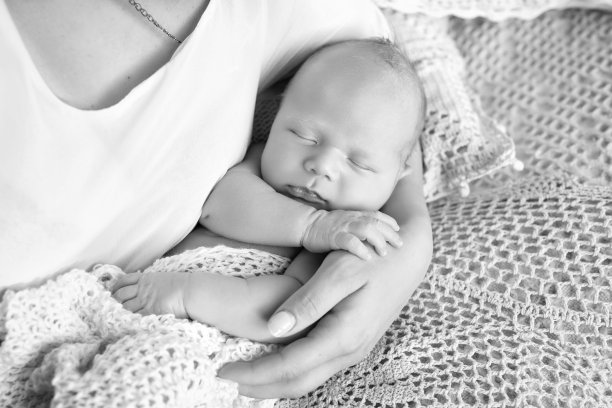 可爱的宝宝睡在妈妈的手里。特写照片。快乐的母亲和她在床上滑倒的新生儿图片下载