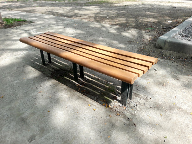 城市公园的木凳。公园里的棕色塑料木长椅让人们休息图片下载