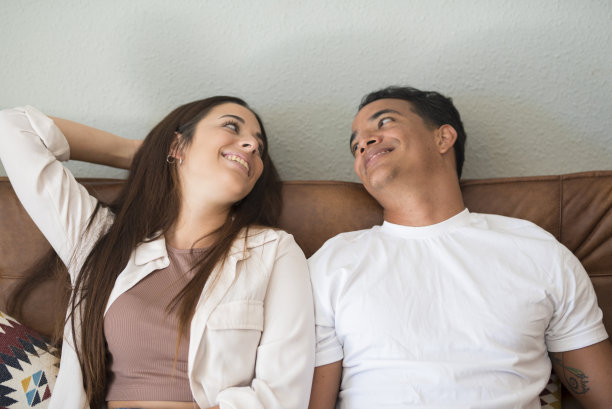 甜蜜的情侣梦想着他们的未来。黑人男孩和白人女孩约会后喜欢一起坐在家里的沙发上放松。幸福和人际关系。看着对方图片下载