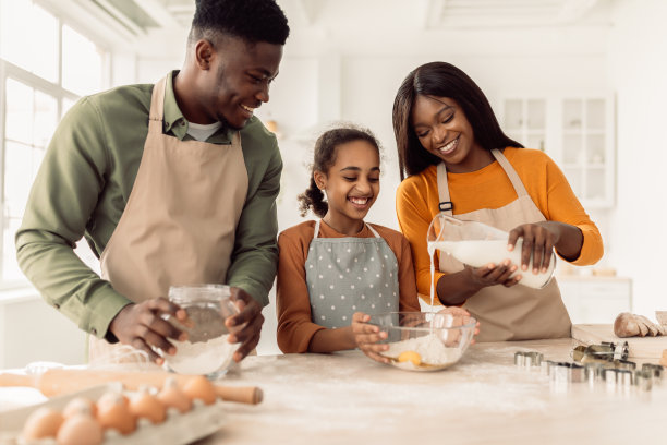 黑人家庭烘焙饼干，在厨房里往面团里加牛奶图片下载