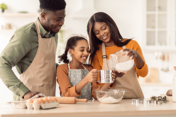 非裔美国家庭在厨房用面粉筛烤饼干图片下载