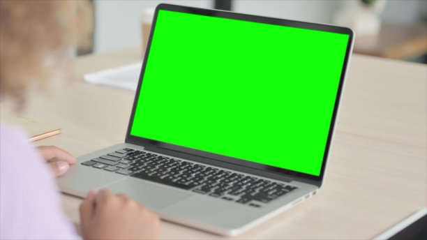 非洲妇女使用绿屏笔记本电脑的特写图片下载