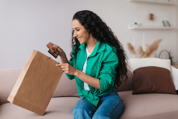 快乐的女人拿着化妆品开箱袋坐在家里图片下载