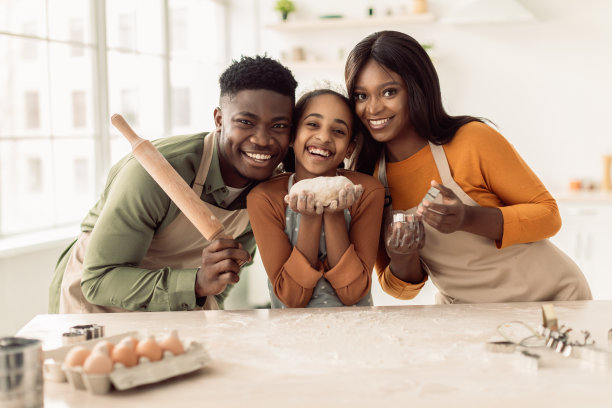 非洲家庭在厨房里拿着烘焙工具摆姿势图片下载