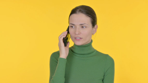 美女在黄色背景下打电话图片下载