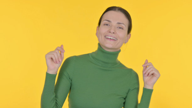 在黄色背景上跳舞的美丽女人图片下载