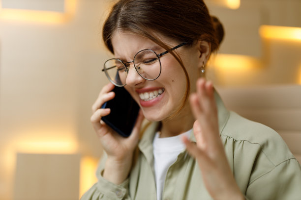 一个年轻女人在电话里怒气冲冲地说，又烦又沮丧，技术支持。图片下载
