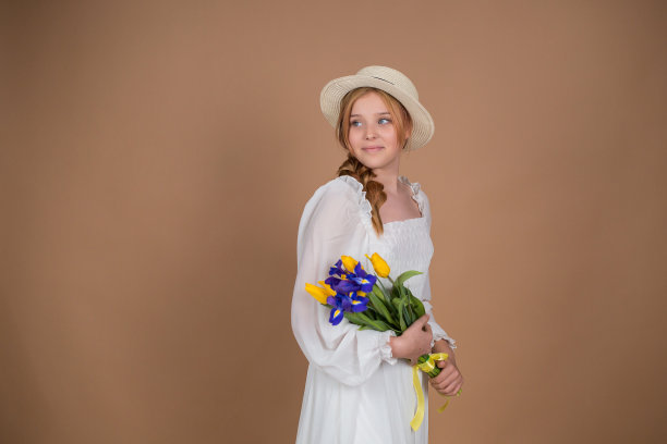 一名身穿白色连衣裙、头戴白色帽子的女子手持一束郁金香和鸢尾花。3月8日。妇女节。女性的节日。妈妈的节日。一束花。
米色背景上带花的女孩图片下载
