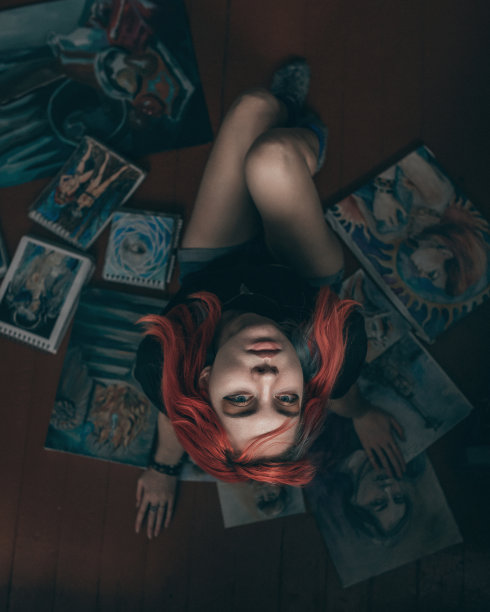 年轻的红发女艺术家和她的画坐在地板上图片下载