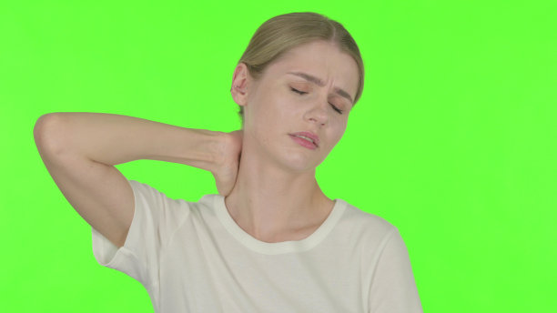 年轻女性颈部疼痛，绿色背景图片下载