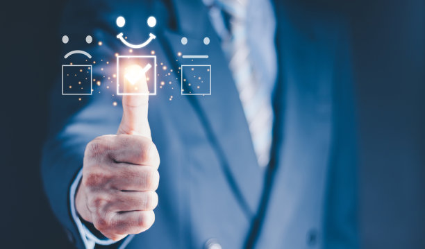 客户服务评价最佳优秀企业评价体验理念。微笑的男子使用智能手机，并按下面部表情满意地微笑在虚拟触摸屏上。图片下载