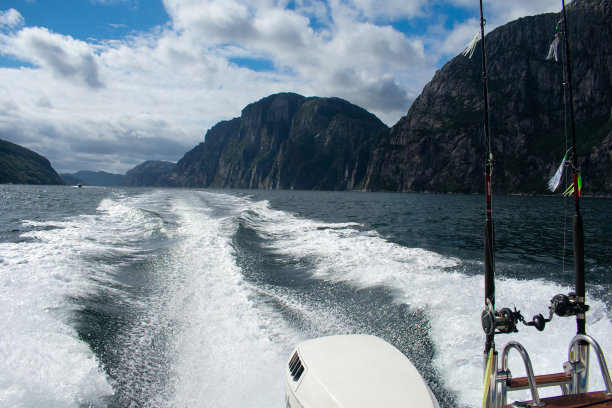 带着鱼竿和渔具的船，背景是风景优美的山脉/峡湾——挪威图片下载