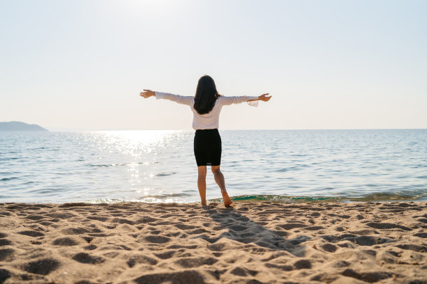 在海滩上感到轻松的年轻女子图片下载