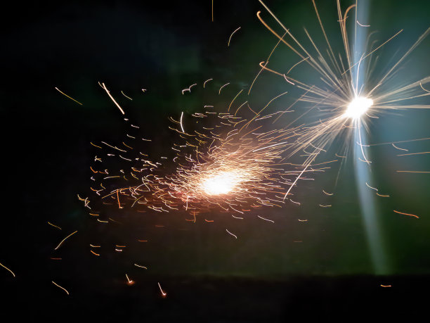 新年美丽的烟花火花效果，黄色和红色的烟花，孤立的黑色背景图片下载