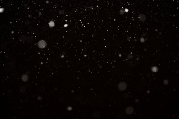 黑色背景上孤立的降雪。抽象的白色散景背景。图片下载