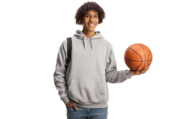 一名非洲裔美国学生手里拿着篮球，面带微笑图片下载