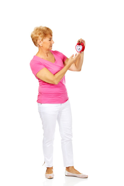 全身照是一位波兰老妇人，穿着夏装，拿着闹钟，被白色隔开图片下载