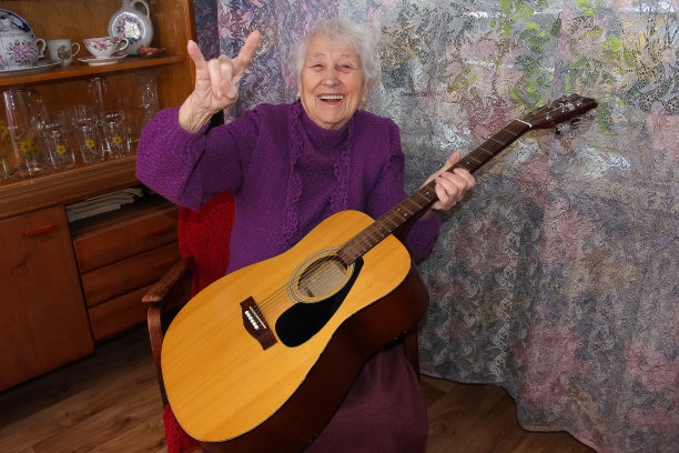 老年妇女在家里弹吉他图片下载
