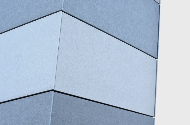 带有扩展金属晶格结构的建筑物的石膏板包层。镀锌灰色网保护工业建筑。蓝色的天空与银色的背景形成对比，墙壁、角落、倾斜图片下载