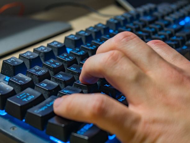 男性在晚上工作时用背光键盘打字图片下载