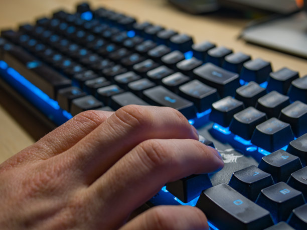 男性在晚上工作时用背光键盘打字图片下载