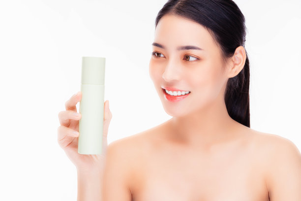 美丽的亚洲女性模特抱着化妆品瓶微笑美丽的亚洲女性展示护肤瓶产品美丽的脸身体肖像隔离在白色背景复制空间她看着产品图片下载