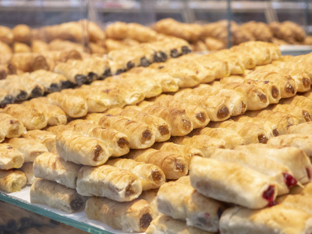 货架上的玻璃后面的烘焙食品的图像。图片下载