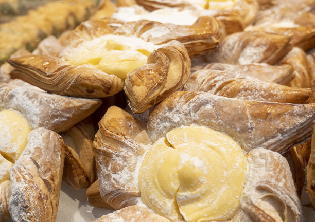 货架上的玻璃后面的烘焙食品的图像。图片下载