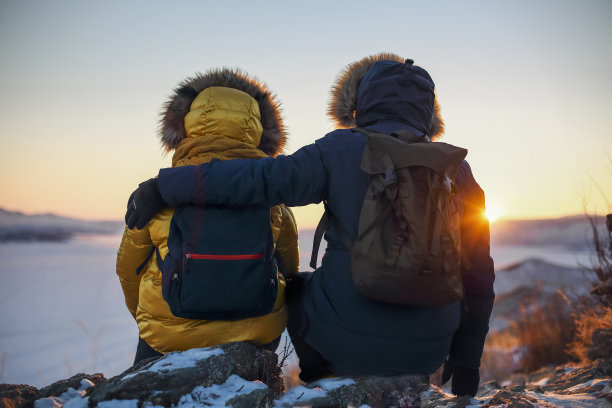 一对浪漫的游客情侣穿着温暖的冬季运动服，背着旅游背包图片下载