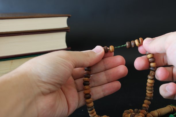 穆斯林用可兰经背景上的念珠祈祷的手图片下载