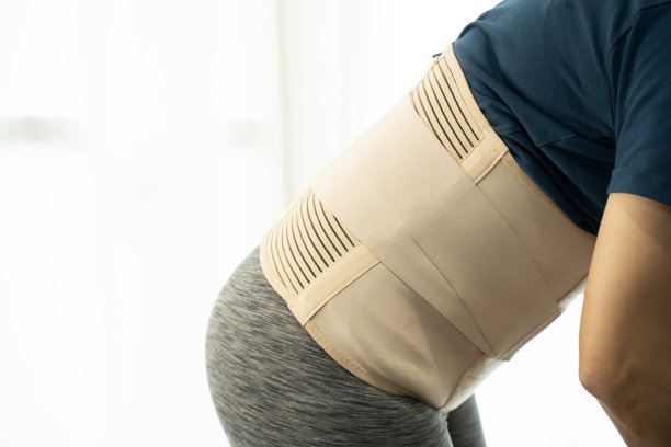 年轻的亚洲女性穿着背部支撑，保护她的背部，药物和健康的概念图片下载