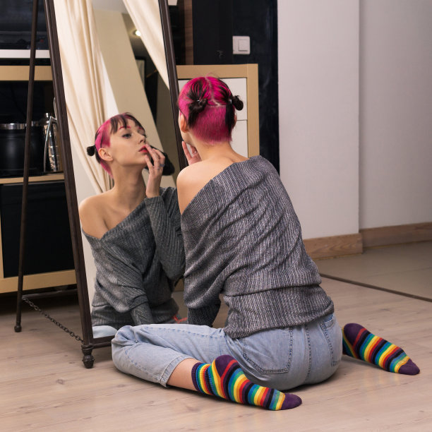 十几岁的女孩在工作室看着镜子，仔细检查她的脸图片下载