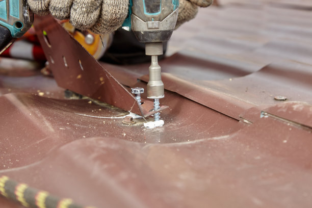 屋顶修复。用绳子到屋顶。一个男人在修理一座大厦的屋顶。图片下载