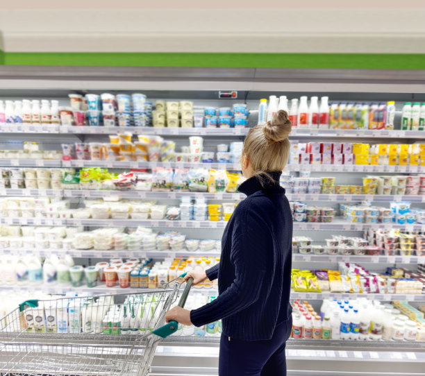 一名妇女从超市冷冻室挑选冷冻食品图片下载