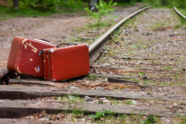两个被遗忘的复古行李箱放在户外封闭的旧铁轨上。时尚的形象复古行李箱站在森林在铁路背景。旅游度假概念。复制广告的文字空间图片下载
